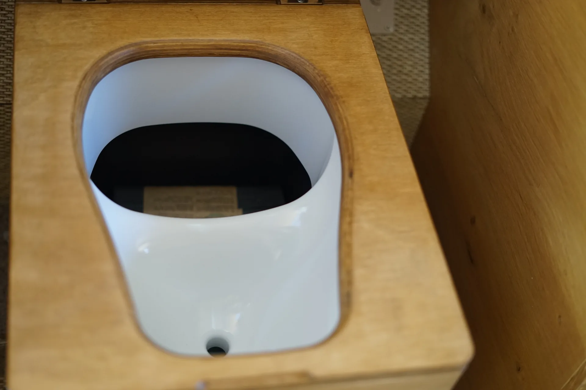 Vue de dessus du séparateur d'urine des toilettes sèches montrant la séparation liquide et solide et le bac en place